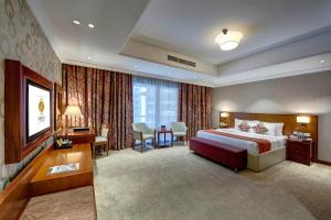迪拜多纳泰罗酒店的大型酒店客房,配有一张床和一张书桌