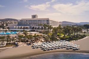 利马索尔Parklane, a Luxury Collection Resort & Spa, Limassol的享有带遮阳伞和海滩的度假村的空中景致