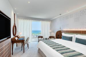 利马索尔Parklane, a Luxury Collection Resort & Spa, Limassol的一间酒店客房,设有一张大床和一个大窗户