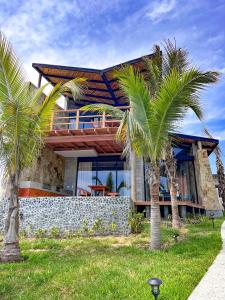 维加伊托DIEM Vichayito Beachfront Eco-Luxury的前面有棕榈树的房子