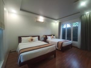 富国GREENSPACE RESORT PHUQUOC的酒店客房设有两张床和窗户。