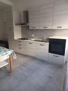 波尔图桑特埃尔皮迪奥Appartamento Civico Trentuno的厨房配有白色橱柜和黑烤箱。