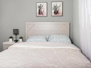 伊丽莎白Stylish & family friendly 3 Bedroom - 8 mins to EWR的卧室配有一张墙上三幅照片的床