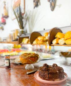 阿拉卡茹Pousada dos Caminhos的一张桌子,上面放着巧克力蛋糕和一盘面包