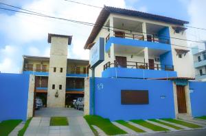 阿拉卡茹Pousada dos Caminhos的蓝色和白色的房子,设有停车场