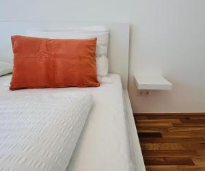 维也纳A Cozy Flat with Flair surrounded by Nature的房间里的床上的橙色枕头
