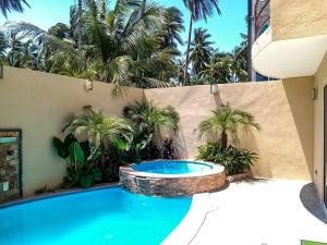 阿卡普尔科Villa De Santos Acapulco Playa Bonfil Alberca的棕榈树后院的游泳池