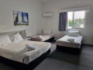 西南岩海风沙滩酒店的酒店客房设有两张床和窗户。