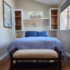 圣罗莎Amitabha Wine Country Cottage的一间卧室配有一张带蓝色枕头的床和长凳。