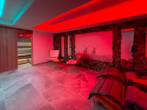 蒂罗尔州圣约翰Hotel Crystal - KitzHorn Suites的红色灯光和红色椅子的房间