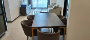 吉隆坡Opus Residences Warisan Merdeka by C&C Fortune的一间带桌子和一些棕色椅子的用餐室