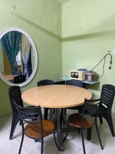 Kampong Alor GajahHomestay Zalida C Musleem的镜子间里的桌椅