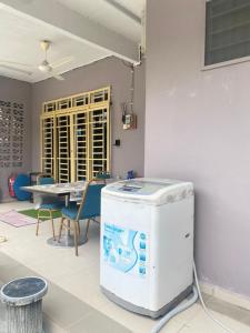Kampong Alor GajahHomestay Zalida C Musleem的配有桌椅和加热器的房间