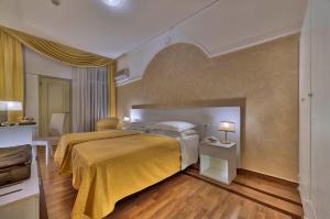 阿巴诺泰尔梅特尔姆帕特里亚酒店的一间卧室配有一张带黄色毯子的大床