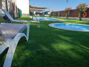 Ríolobos拉斯卡塔利纳斯露营地酒店的游泳池旁的草地上的一个白色长凳