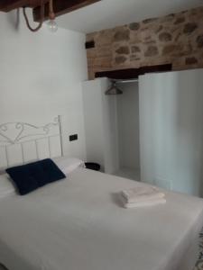 托莱多SEÑORÍO DE ORGAZ III的卧室配有白色床和蓝色枕头