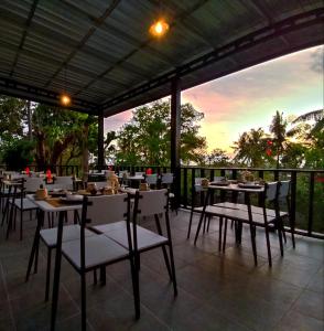 圣吉吉Melasa House的餐厅设有桌椅,享有日落美景。