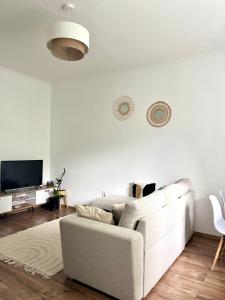 布达佩斯Beethoven Apartman的白色的客厅配有白色的沙发和电视