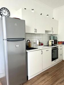 布达佩斯Beethoven Apartman的厨房配有白色橱柜和不锈钢冰箱