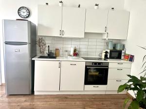 布达佩斯Beethoven Apartman的厨房配有白色橱柜和冰箱。