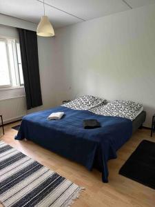 托尔尼奥CheapRooms in Tornio city的一间卧室配有一张蓝色床罩的床