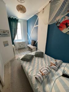滨海图维列Le Bleu的一间卧室配有一张带蓝色墙壁的大床