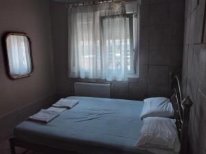 尼亚米卡尼奥纳Ariadne Apartments的一间小卧室,配有一张带窗户的床