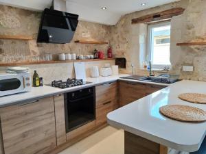La Tour-BlancheBarn cottage的厨房配有水槽和炉灶 顶部烤箱