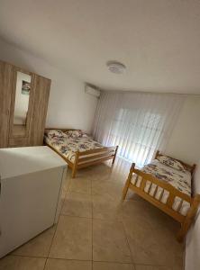 乌尔齐尼Apartments Edona的客房设有两张床和一台冰箱。