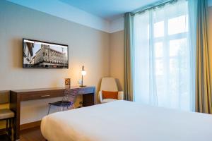 圣地亚哥－德孔波斯特拉孔波斯特拉酒店的配有一张床、一张书桌和一扇窗户的酒店客房