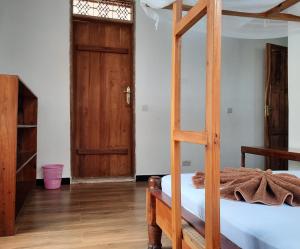 南威Kajificheni House的一间卧室设有一张双层床和一扇木门。