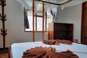 南威Kajificheni House的一间卧室配有带毛巾的床