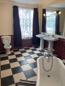罗切斯特皇家维多利亚与布尔酒店的带浴缸、两个盥洗盆和卫生间的浴室