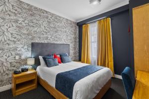 汉密尔顿Ramada by Wyndham, Hamilton City Center的一间卧室配有一张带蓝色墙壁的大床