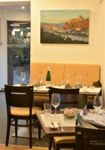 AylLinden's Pension-Restaurant的配有桌椅和酒杯的餐厅