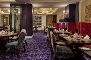 西安西安阳光国际大酒店 的餐厅配有木桌和椅子,铺有紫色地毯