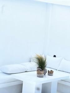 皮索利瓦迪Sunsenses villa Ariadne的白色咖啡桌,上面有盆栽植物
