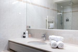 圣米歇尔山圣米歇尔驿站酒店的浴室配有盥洗盆、镜子和毛巾
