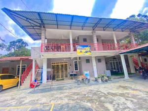 Kampong Alor GajahHomestay Zalida D Musleem的蓝色屋顶和黄色汽车的房子