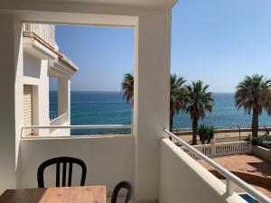 内尔哈Fuentes de Nerja的阳台配有桌子,享有海景。