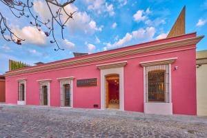 瓦哈卡市City Centro by Marriott Oaxaca的粉红色的建筑,顶部有陡峭的