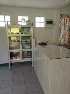 班克鲁特2-bed house near beach w/ aircon的厨房配有柜台和冰箱。