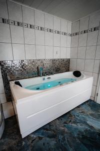 EllarTimeout Royal的瓷砖浴室设有白色浴缸。