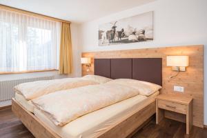采尔马特菲利斯度假别墅酒店的一间卧室配有一张大床和木制床头板