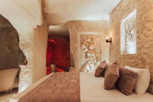 乌奇希萨尔Harem Suites Cappadocia的一间卧室配有带枕头的床