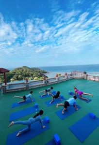 涛岛Ko Tao Resort Paradise Zone - SHA Plus的一群人在度假村的屋顶上做瑜伽
