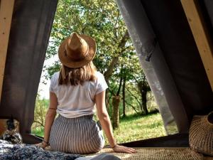 内伊韦Tipì Glamping Gilda的坐在床上看着窗外的女人