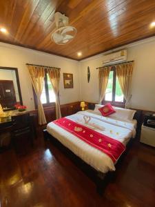 琅勃拉邦Golden Lotus Boutique Hotel的一间卧室设有一张带木制天花板的大床