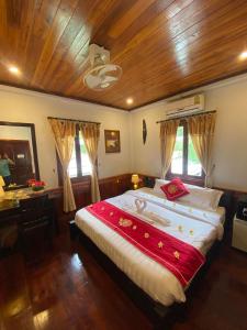 琅勃拉邦Golden Lotus Boutique Hotel的一间卧室设有一张带木制天花板的大床