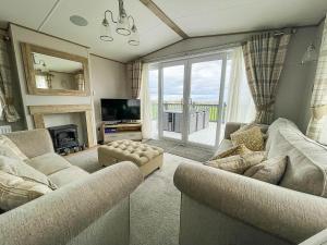 Hopton on SeaLuxury Lodge With Stunning Full Sea Views In Suffolk Ref 20234bs的客厅配有两张沙发和一台电视